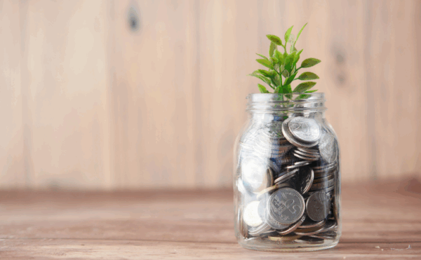 ETF Police vs. Traditionelle Fonds โ Welche Anlageform lohnt sich wirklich? Glas voller Mรผnzen mit wachsender Pflanze โ Symbol fรผr Vermรถgensaufbau und nachhaltige Geldanlage.